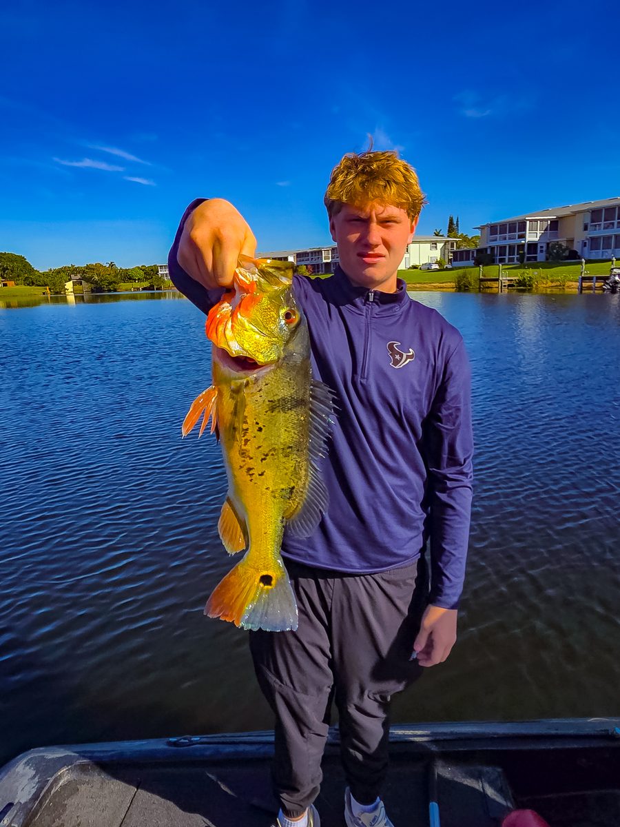 Asher Price holding a peacock bass he caught